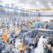 Moderne industrielle Fertigungshalle mit vernetzten Produktionsmaschinen und automatisierten Anlagen