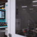 Bedienfeld mit Steuerungsmonitor einer CNC-Maschine in moderner Fertigungshalle